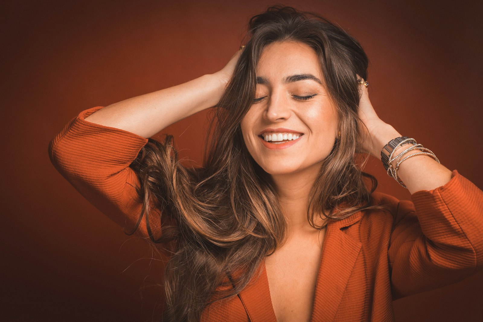 Femme souriante tenant ses longs cheveux